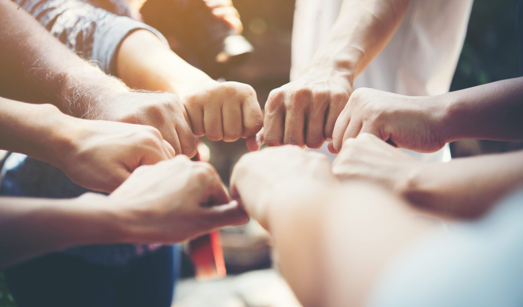 Close up of young people putting their hands together. Team with stack of hands showing unity and teamwork.